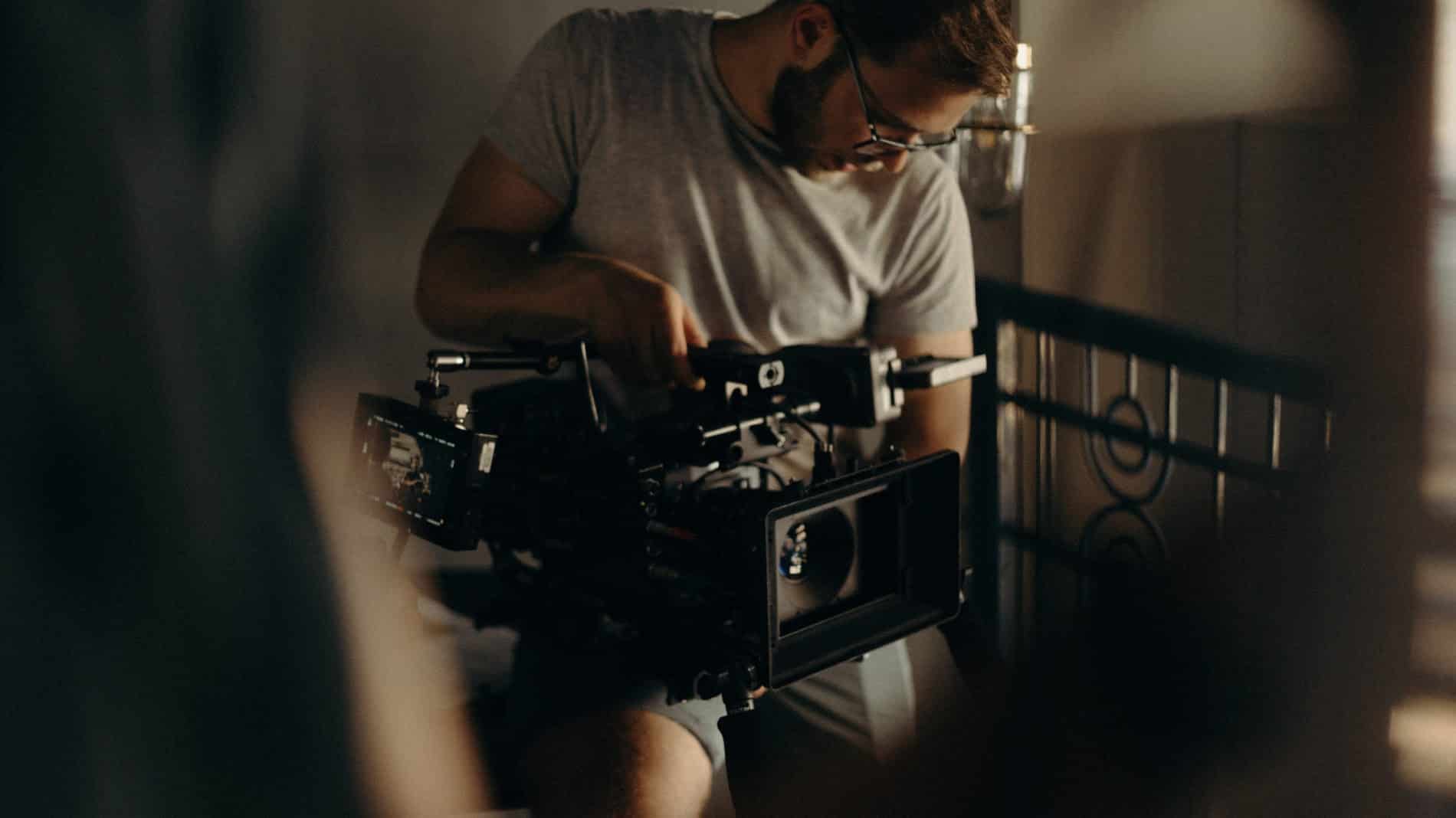 a man holding a camera while sitting on a balcony